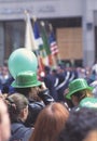 Happy people with green bowler hats and balloons cheering at St. PatrickÃ¢â¬â¢s Day parade in the streets